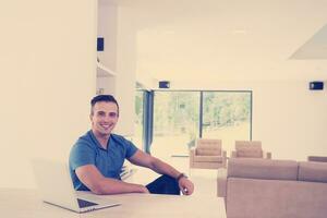 Young man with laptop at home photo