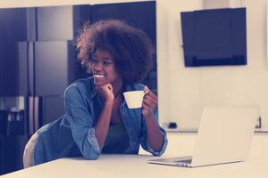 smiling black woman in modern kitchen photo