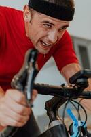A man riding a triathlon bike on a machine simulation in a modern living room. Training during pandemic conditions. photo