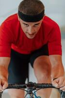 A man riding a triathlon bike on a machine simulation in a modern living room. Training during pandemic conditions. photo