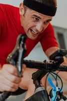 A man riding a triathlon bike on a machine simulation in a modern living room. Training during pandemic conditions. photo