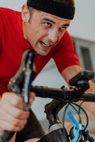 A man riding a triathlon bike on a machine simulation in a modern living room. Training during pandemic conditions. photo