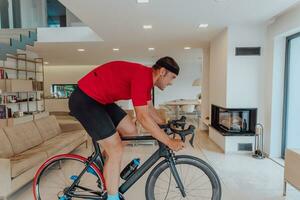 A man riding a triathlon bike on a machine simulation in a modern living room. Training during pandemic conditions. photo