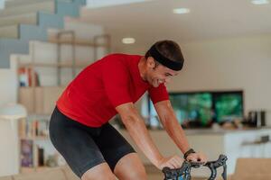 un hombre montando un triatlón bicicleta en un máquina simulación en un moderno vivo habitación. formación durante pandemia condiciones. foto