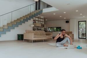 Training At Home. Sporty man doing training while watching online tutorial on laptop, exercising in living room, free space photo