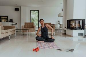 Young Beautiful Female Exercising, Stretching and Practising Yoga with Trainer via Video Call Conference in Bright Sunny House. Healthy Lifestyle, Wellbeing and Mindfulness Concept. photo