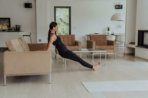 Young Beautiful Female Exercising, Stretching and Practising Yoga with Trainer via Video Call Conference in Bright Sunny House. Healthy Lifestyle, Wellbeing and Mindfulness Concept. photo