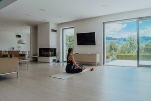 Young Beautiful Female Exercising, Stretching and Practising Yoga with Trainer via Video Call Conference in Bright Sunny House. Healthy Lifestyle, Wellbeing and Mindfulness Concept. photo