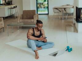 Training At Home. Sporty man doing training while watching online tutorial on laptop, exercising in living room, free space. photo