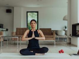 Young Beautiful Female Exercising, Stretching and Practising Yoga with Trainer via Video Call Conference in Bright Sunny House. Healthy Lifestyle, Wellbeing and Mindfulness Concept. photo