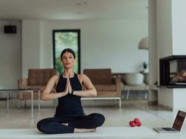 Young Beautiful Female Exercising, Stretching and Practising Yoga with Trainer via Video Call Conference in Bright Sunny House. Healthy Lifestyle, Wellbeing and Mindfulness Concept. photo