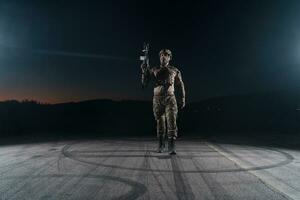 Ejército soldado en combate uniformes con un asalto rifle, plato portador y combate casco yendo en un peligroso misión en un lluvioso noche. foto