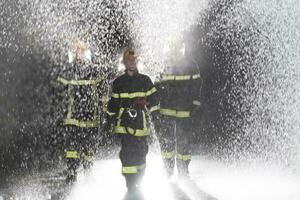 retrato de un grupo de bomberos en pie y caminando valiente y optimista con un hembra como equipo líder. foto