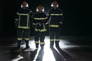 retrato de un grupo de bomberos en pie y caminando valiente y optimista con un hembra como equipo líder. foto