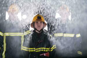 Portrait of a group of firefighters standing and walking brave and optimistic with a female as team leader. photo