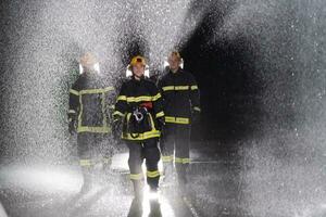 retrato de un grupo de bomberos en pie y caminando valiente y optimista con un hembra como equipo líder. foto