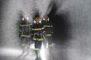 Portrait of a group of firefighters standing and walking brave and optimistic with a female as team leader. photo