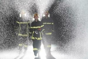 Portrait of a group of firefighters standing and walking brave and optimistic with a female as team leader. photo