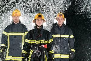 Portrait of a group of firefighters standing and walking brave and optimistic with a female as team leader. photo