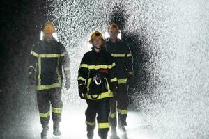 Portrait of a group of firefighters standing and walking brave and optimistic with a female as team leader. photo