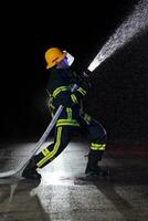 bombero en fuego luchando operación. retrato de un heroico bombero en un protector traje y rojo casco en acción durante pesado lluvia. foto