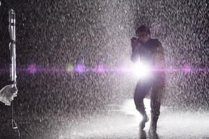 Army soldier in Combat Uniforms with an assault rifle, plate carrier and combat helmet going on a dangerous mission on a rainy night. photo