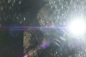 Army soldier in Combat Uniforms with an assault rifle, plate carrier and combat helmet going on a dangerous mission on a rainy night. photo