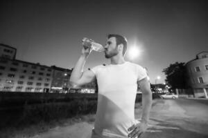 man drinking water after running session photo