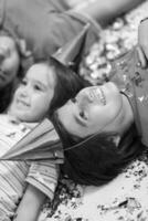 kids  blowing confetti while lying on the floor photo