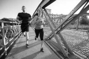 pareja joven corriendo por el puente en la ciudad foto