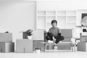 boy sitting on the table with cardboard boxes around him photo