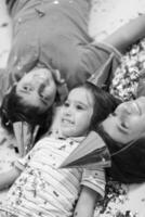 kids  blowing confetti while lying on the floor photo