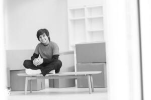 boy sitting on the table with cardboard boxes around him photo