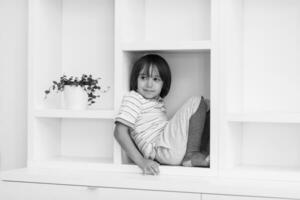 young boy posing on a shelf photo