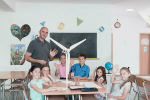 elemental colegio vástago robótica salón de clases diverso grupo de niños edificio y programación molino ecología robot concepto. juntos hablando y trabajando como un equipo. creativo robótica Ingenieria foto