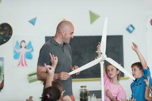 Elementary School Stem Robotics Classroom Diverse Group of Children Building and Programming windmill ecology robot concept. Together Talking and Working as a Team. Creative Robotics Engineering photo