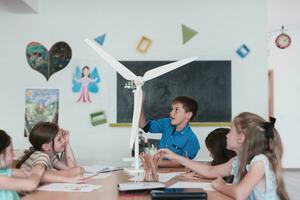 Elementary School Stem Robotics Classroom Diverse Group of Children Building and Programming windmill ecology robot concept. Together Talking and Working as a Team. Creative Robotics Engineering photo