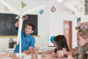 Elementary School Stem Robotics Classroom Diverse Group of Children Building and Programming windmill ecology robot concept. Together Talking and Working as a Team. Creative Robotics Engineering photo