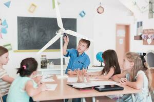 Elementary School Stem Robotics Classroom Diverse Group of Children Building and Programming windmill ecology robot concept. Together Talking and Working as a Team. Creative Robotics Engineering photo