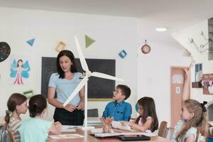 Elementary School Stem Robotics Classroom Diverse Group of Children Building and Programming windmill ecology robot concept. Together Talking and Working as a Team. Creative Robotics Engineering photo