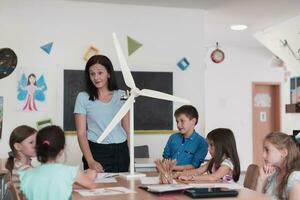 Elementary School Stem Robotics Classroom Diverse Group of Children Building and Programming windmill ecology robot concept. Together Talking and Working as a Team. Creative Robotics Engineering photo