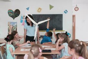 Elementary School Stem Robotics Classroom Diverse Group of Children Building and Programming windmill ecology robot concept. Together Talking and Working as a Team. Creative Robotics Engineering photo