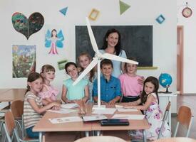 Elementary School Stem Robotics Classroom Diverse Group of Children Building and Programming windmill ecology robot concept. Together Talking and Working as a Team. Creative Robotics Engineering photo