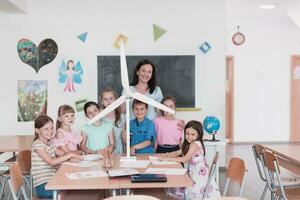 Elementary School Stem Robotics Classroom Diverse Group of Children Building and Programming windmill ecology robot concept. Together Talking and Working as a Team. Creative Robotics Engineering photo