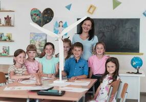 Elementary School Stem Robotics Classroom Diverse Group of Children Building and Programming windmill ecology robot concept. Together Talking and Working as a Team. Creative Robotics Engineering photo