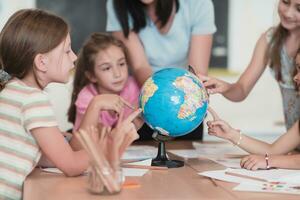 hembra profesor con niños en geografía clase mirando a globo. lado ver de grupo de diverso contento colegio niños con globo en salón de clases a escuela. foto