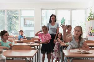 The end of the pandemic. The teacher in the school takes off the protective masks with the students photo