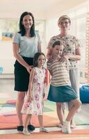 Portrait of a mother with her daughters in a modern preschool institution. Selective focus photo