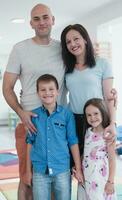 retrato de un contento familia. foto de padres con niños en un moderno preescolar aula. selectivo atención