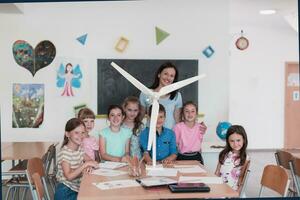 Elementary School Stem Robotics Classroom Diverse Group of Children Building and Programming windmill ecology robot concept. Together Talking and Working as a Team. Creative Robotics Engineering photo